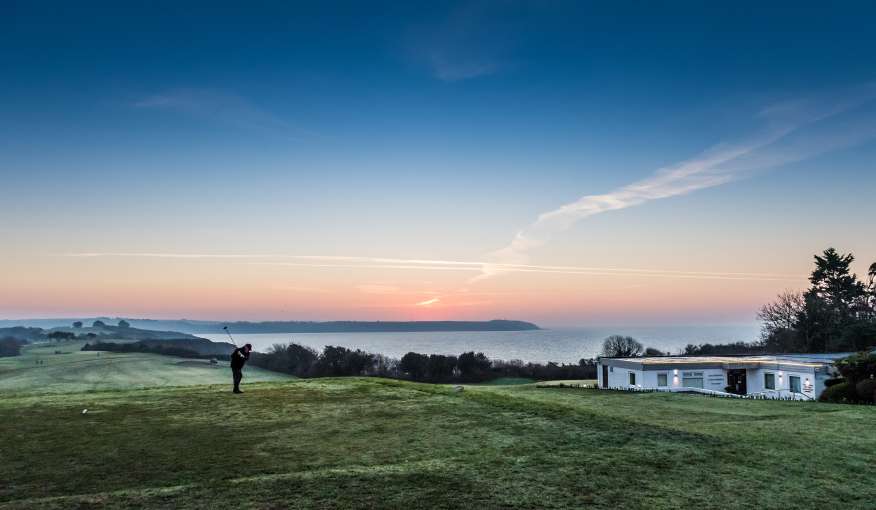 Golfer on first tee fairway and clubhouse
