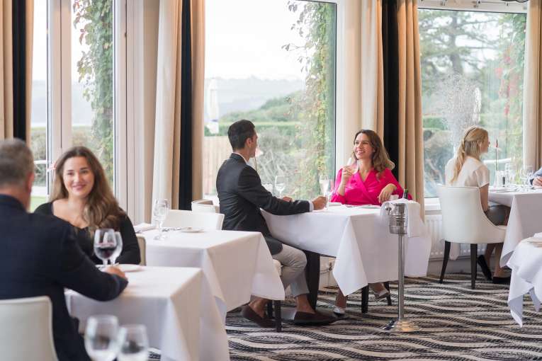 Couple sitting at a table in the Bay View Restaurant, Carlyon Bay Hotel